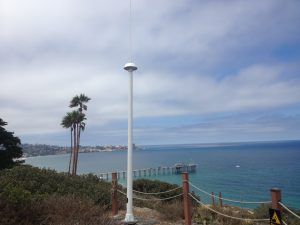 Codar antenna set up on shoreline with palm trees behind