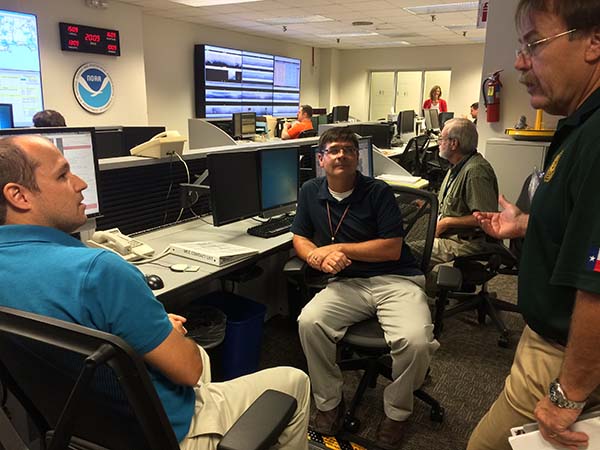 Steve Bushang, Texas General Land Office, talking with NDBC watchstanders at the Texas Automated Buoy System. NDBC mission control center in the back.