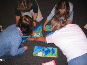 Children working on an ocean observing puzzle on the floor