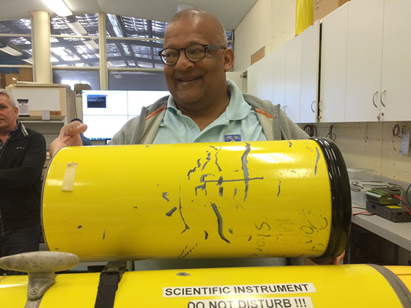 Prof. Charitha Pattiaratchi, Leader, Australian National Facility for Ocean Gliders, holding glider casing with shark bites